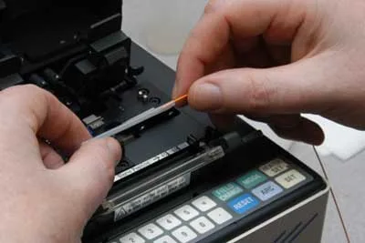 Equipamento de fusão emendando fibras ópticas de enlaces de rede corporativa em Curitiba